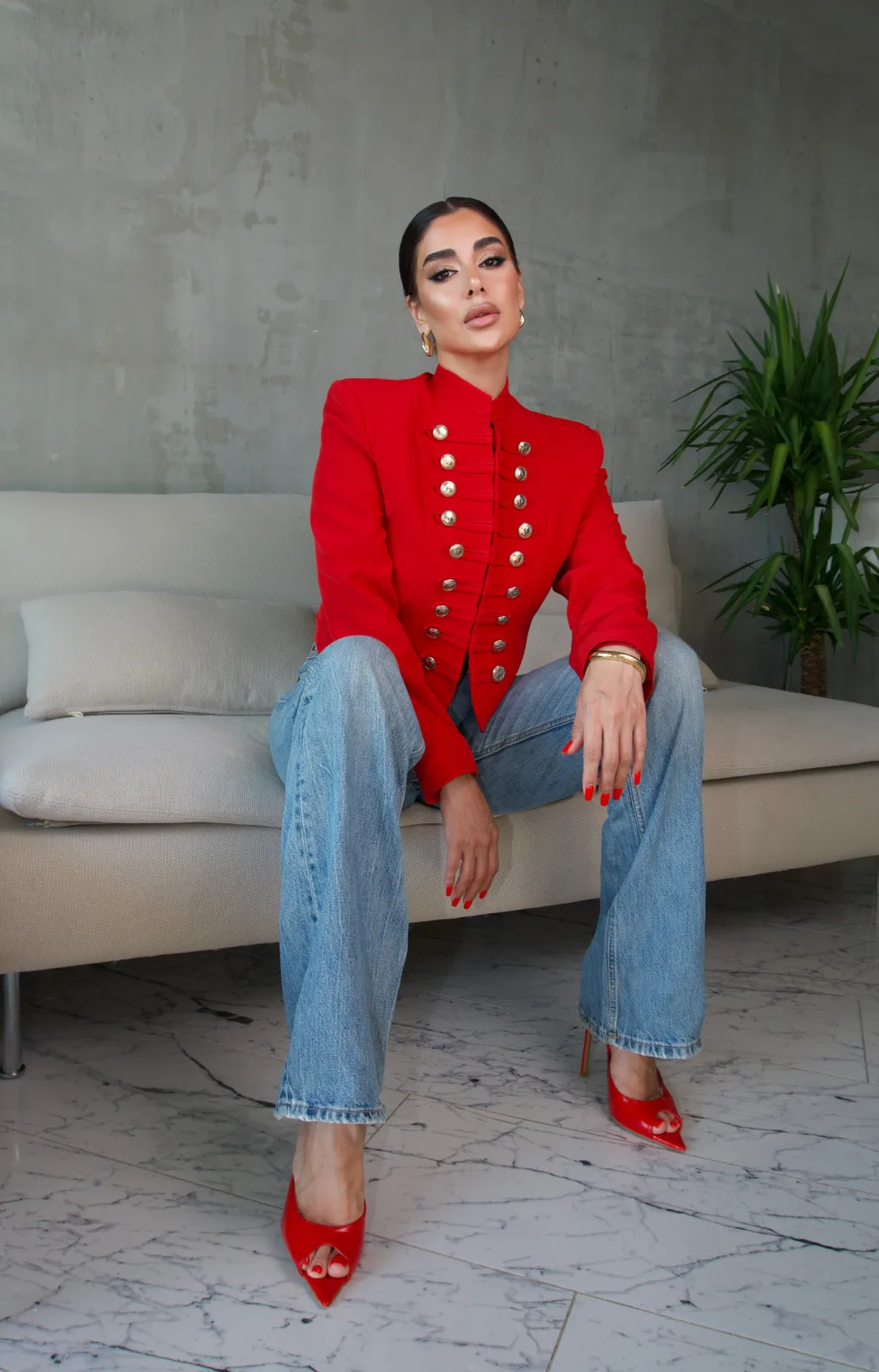 Red bandsman jacket with gold buttons on a cream sofa