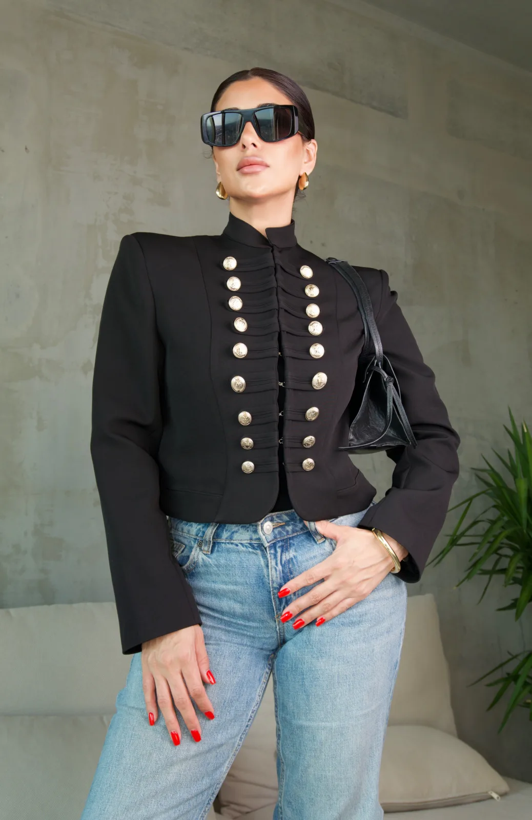 Close view of the twin rows of engraved gold buttons on the black military jacket
